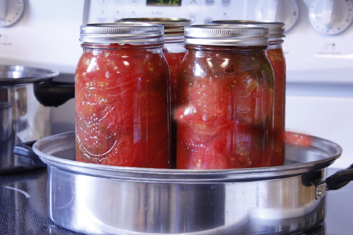 这些夸脱西红柿已经准备好在蒸汽罐头盒里加工了