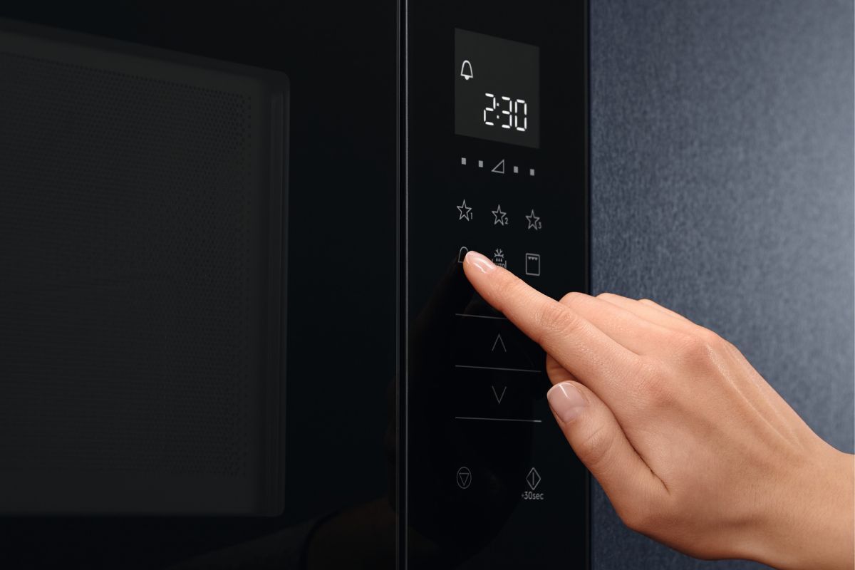 手用圆形按钮设定时间，在家里的厨房里加热微波炉食物。bd手机下载如何在LG微波炉上设置时钟