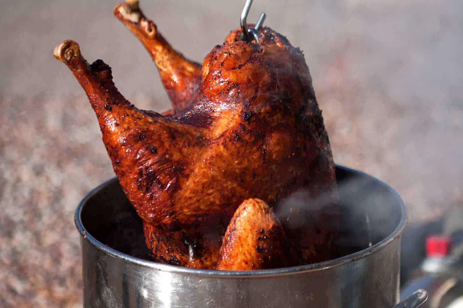 热腾腾的、新鲜可口的火鸡在为节日庆祝活动烹饪后，从深油炸锅中取出