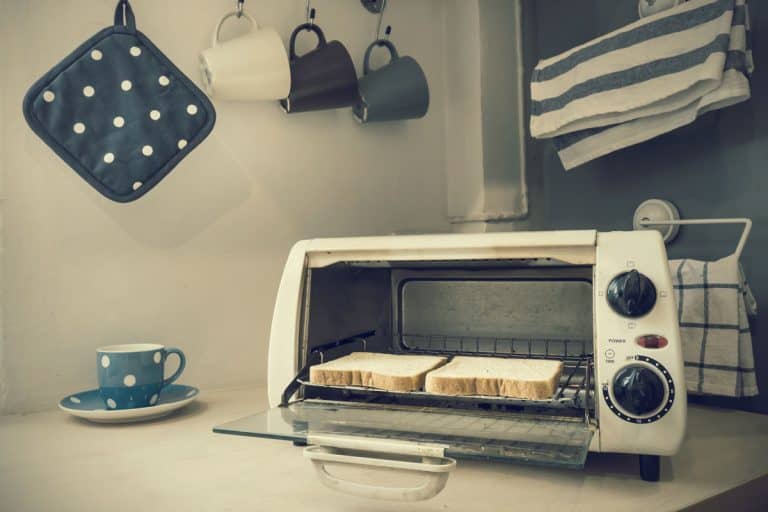 旧烤箱烤面包机和两个面包里面,挂杯的背景,在回收烤箱吗?