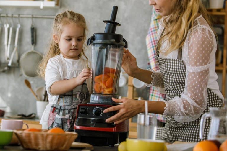 复制空间的年轻女子关闭搅拌机在她蹒跚学步的女儿帮助她在加入新鲜柿子甜点他们一起准备,Vitamix洗碗机安全吗?