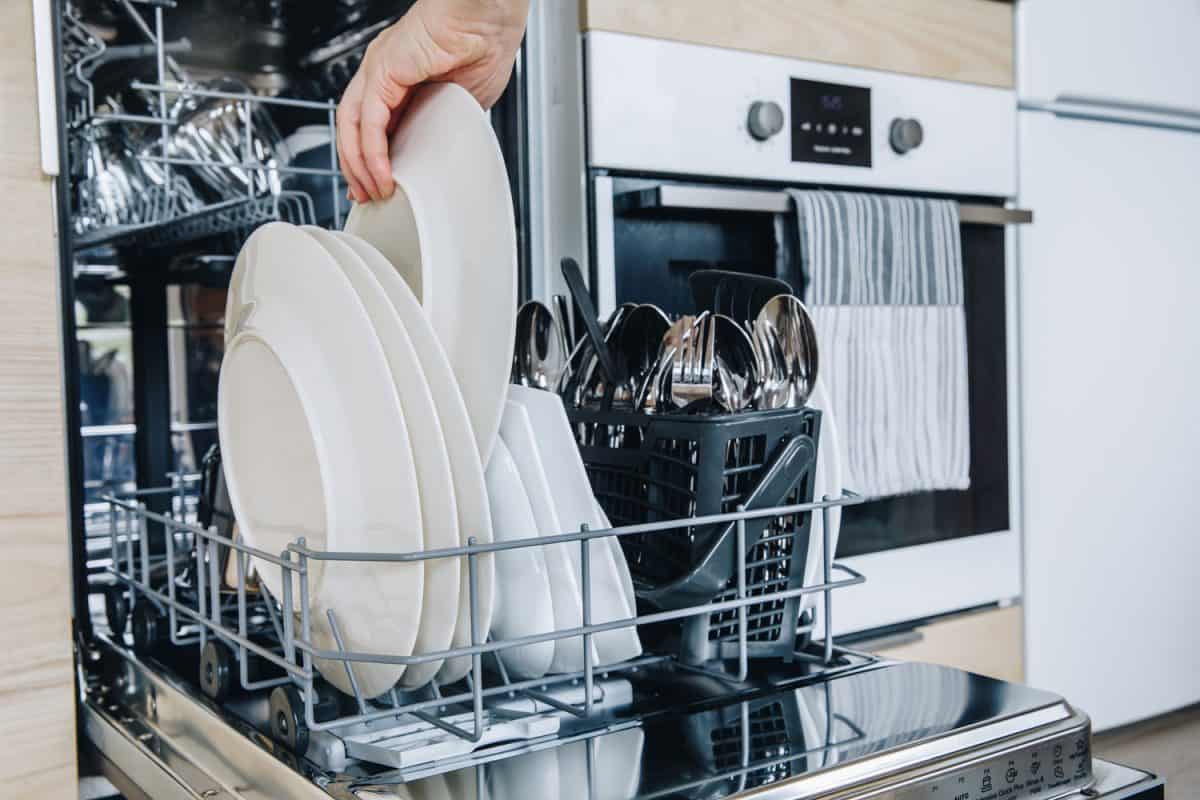 洗完后打开洗碗机，近距离观察干净的杯子和盘子”width=