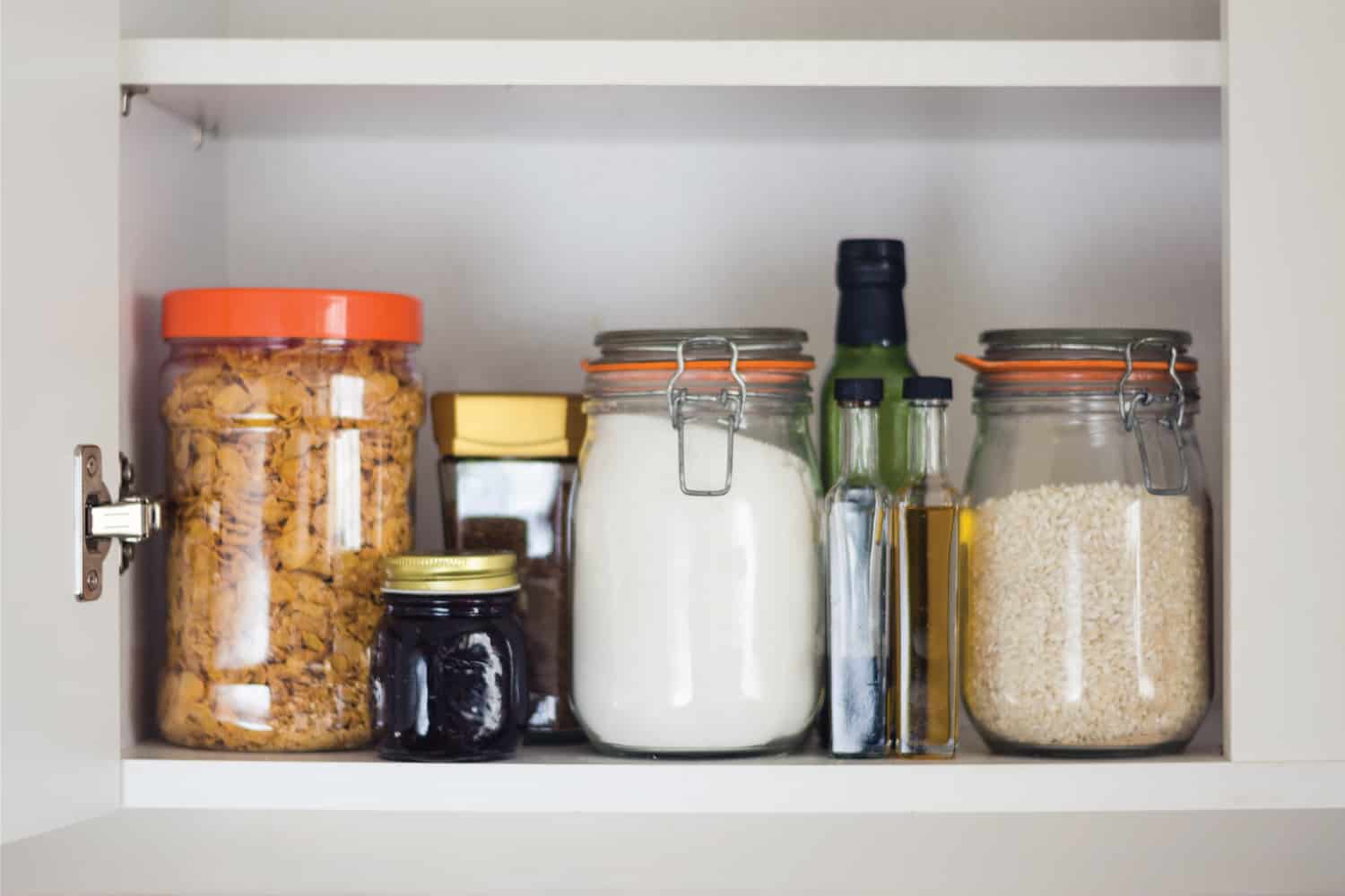 在厨房的食品储藏bd手机下载室里储备食物——玻璃罐子和玻璃容器里的谷物、果酱、咖啡、糖、面粉、油、醋、大米＂width=