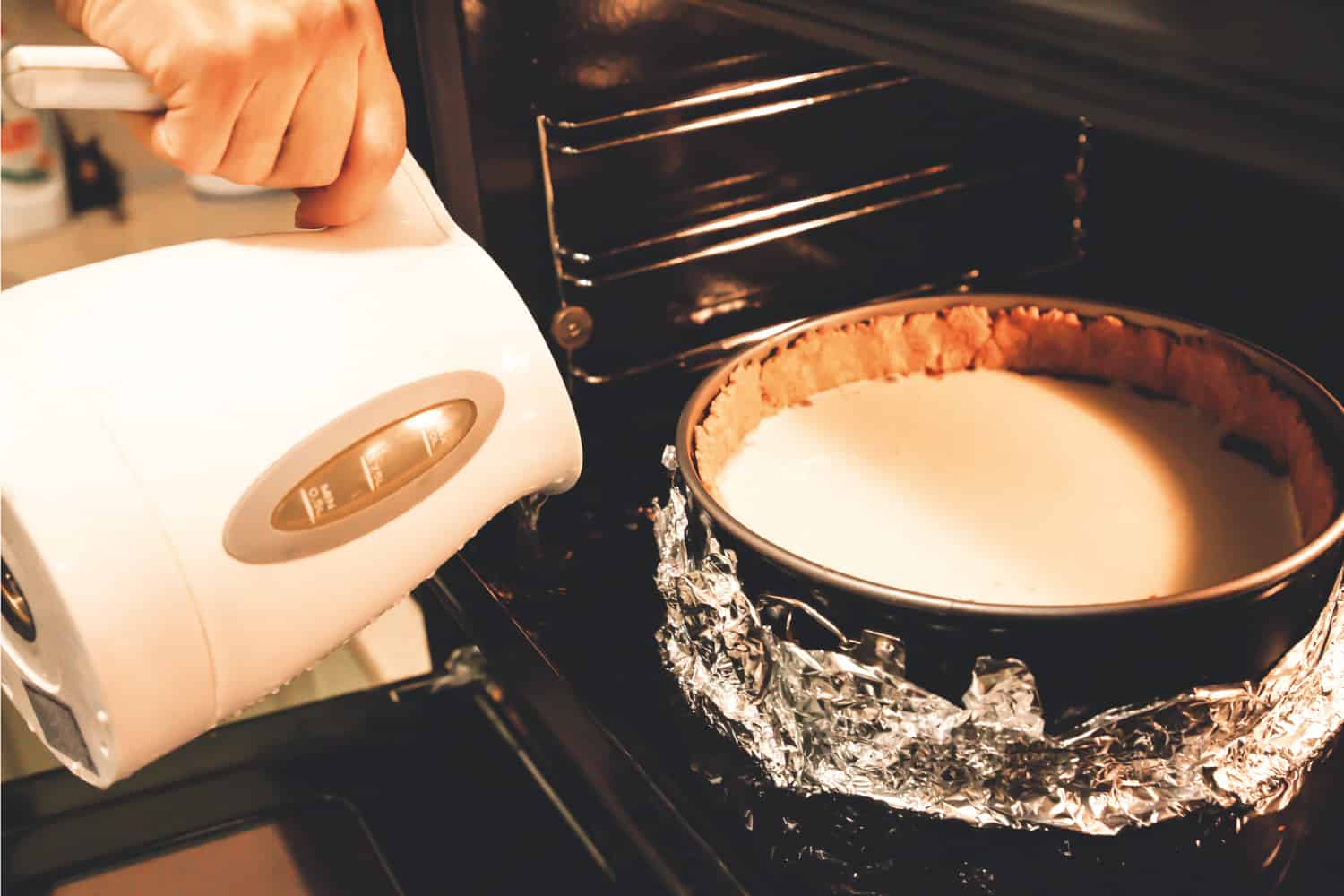 把芝士蛋糕放在烤盘上，用锡箔纸包裹＂width=