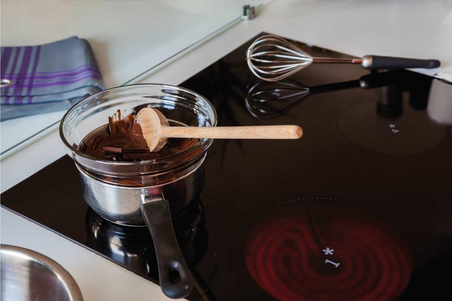 在一个玻璃碗里和一个酱锅里，在电磁炉上加热美味的巧克力