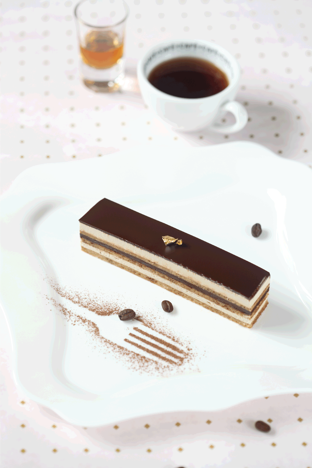 歌剧巧克力咖啡蛋糕在方形白色盘子和一杯咖啡