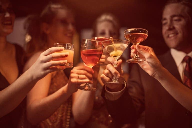 一个男人和四个女人正在庆祝他们的成功喝一杯葡萄酒和鸡尾酒,葡萄酒和鸡尾酒的眼镜如果您有多少?