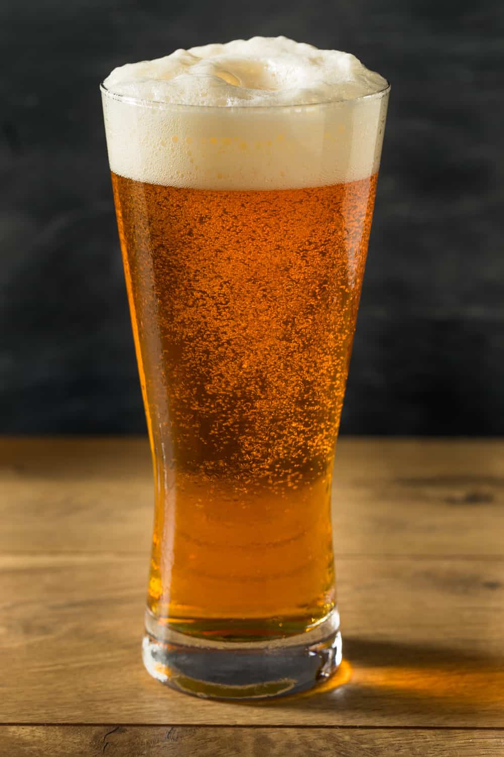 高脚杯盛满泡沫的金色啤酒