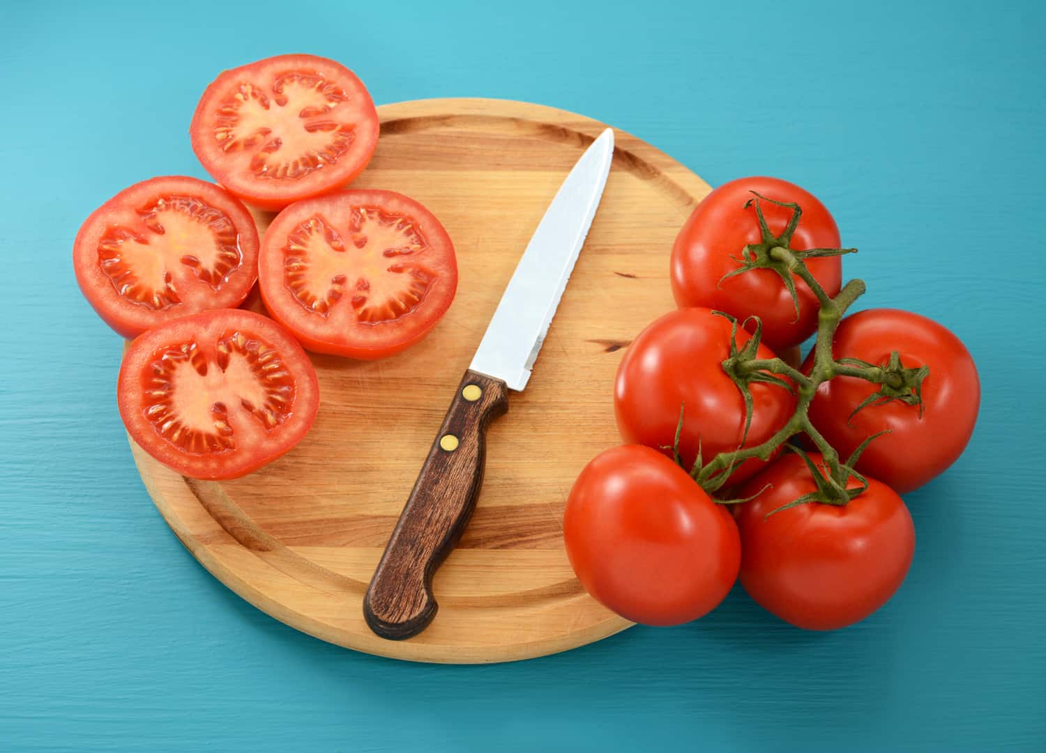 熟番茄，整只，用锯齿刀切成薄片放在木砧板上