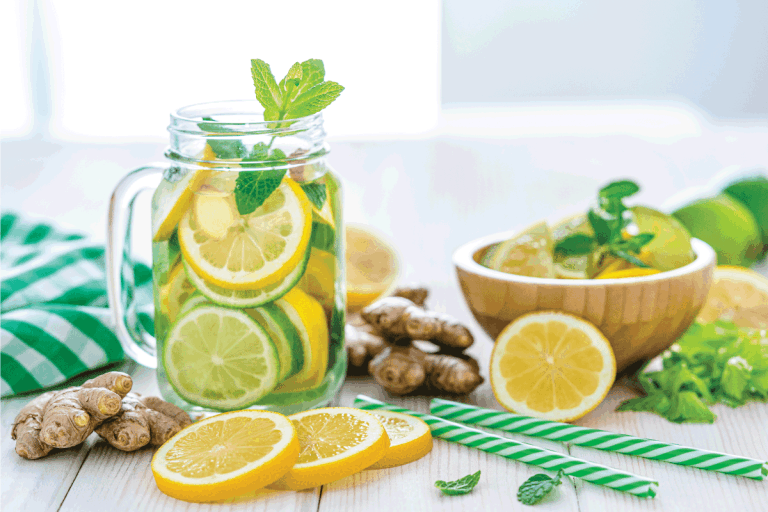 Some-lemon-slices, -ginger-roots-and-two-green-and-white-drinking-straws.-Does-Microwaving-Lemons-And-Lime-Make-Them-Juicier