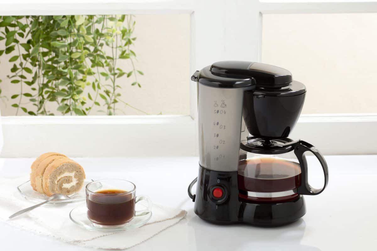 桌上放着咖啡机，旁边放着一小片面包。“Keurig咖啡比滴滤咖啡弱吗?”