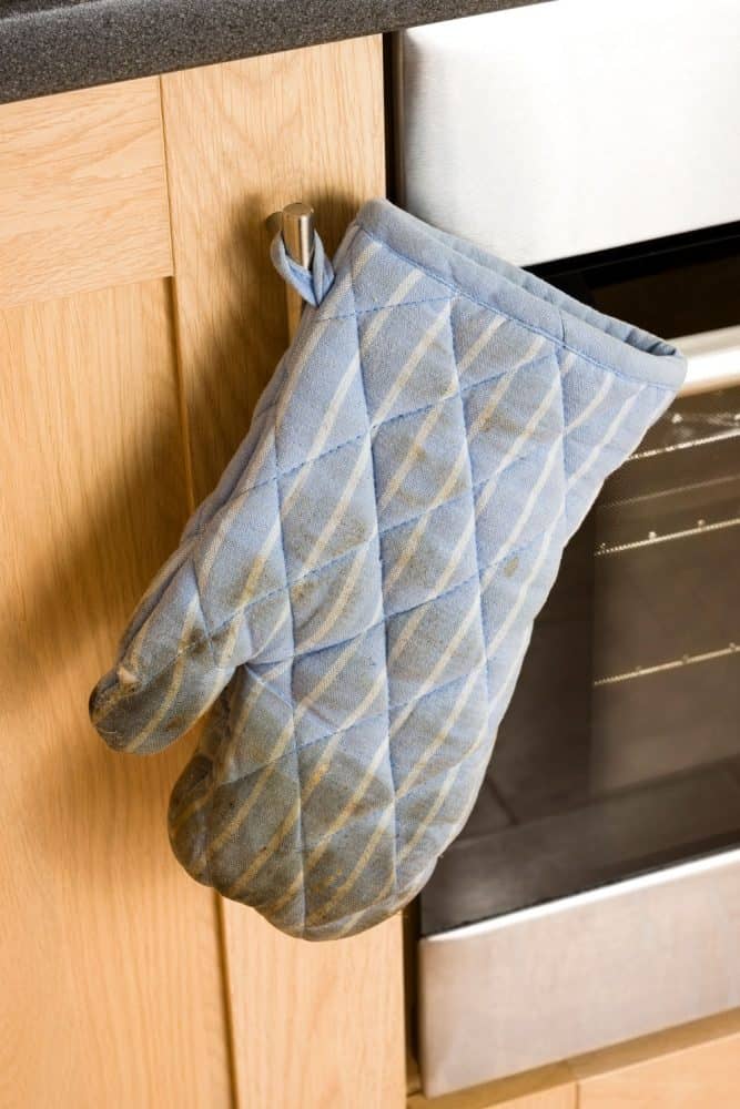 一个稍微制作的烤箱手套挂在烤箱的一边