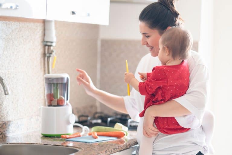 母亲是她的小女儿显示搅拌机。小女儿看着搅拌机。,搅拌机制造婴儿食品好吗?