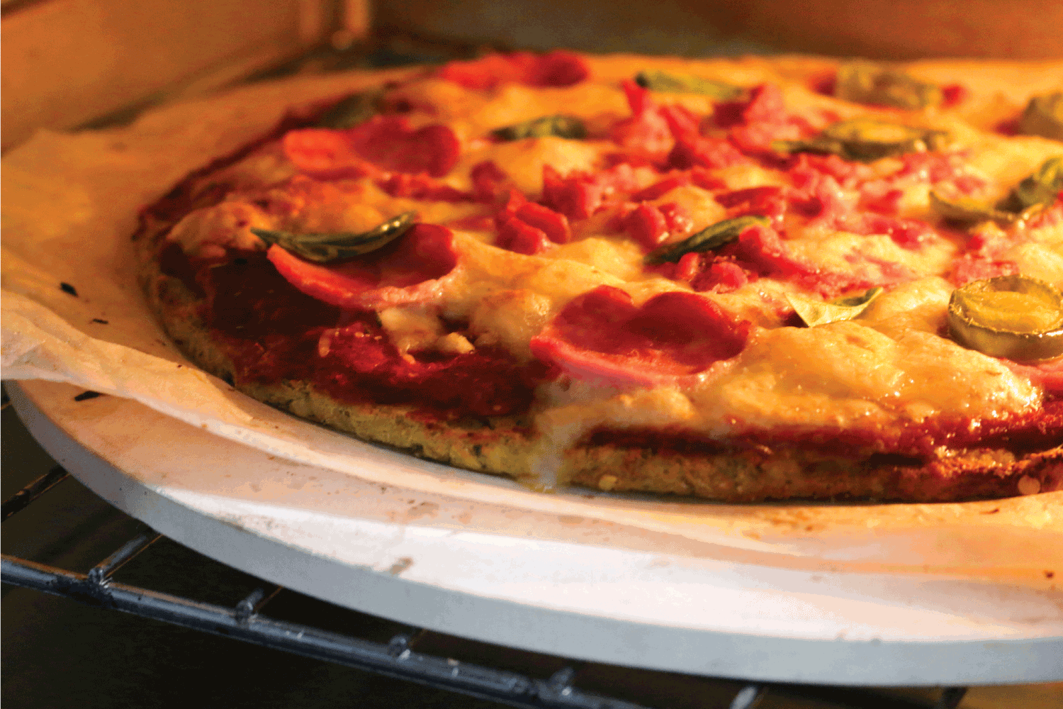 自制的烤披萨食谱，用新鲜的面团和番茄酱浇头，在披萨石上烤，底部薄而脆，意大利辣香肠披萨。