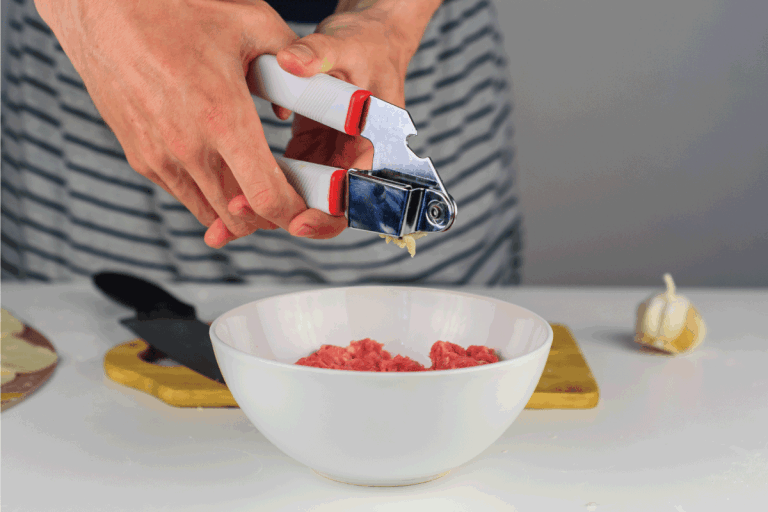 Man-hands-making-stuffing-for-dumplings-with-meat, -crushing-something.-Does-A-Garlic-Press-Work-For-Ginger