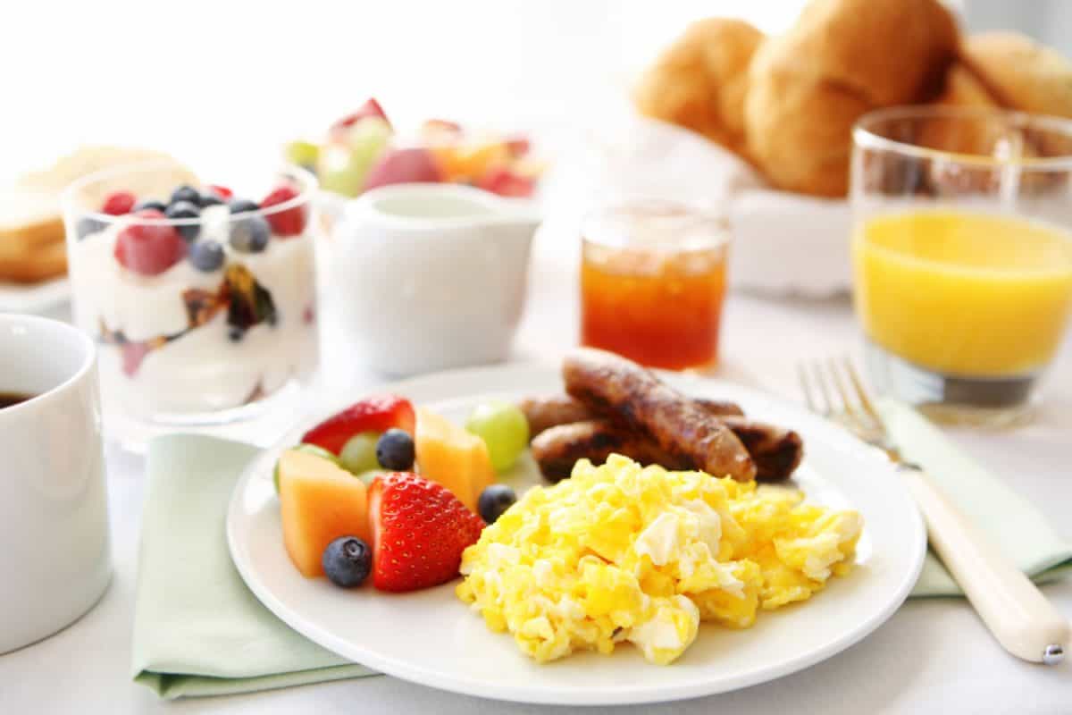 早餐桌上有鸡蛋、水果和香肠