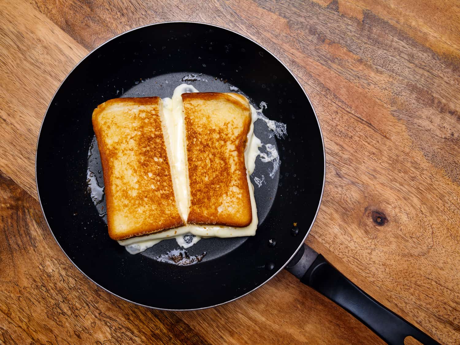 在一个大煎锅里烤奶酪三明治的照片。