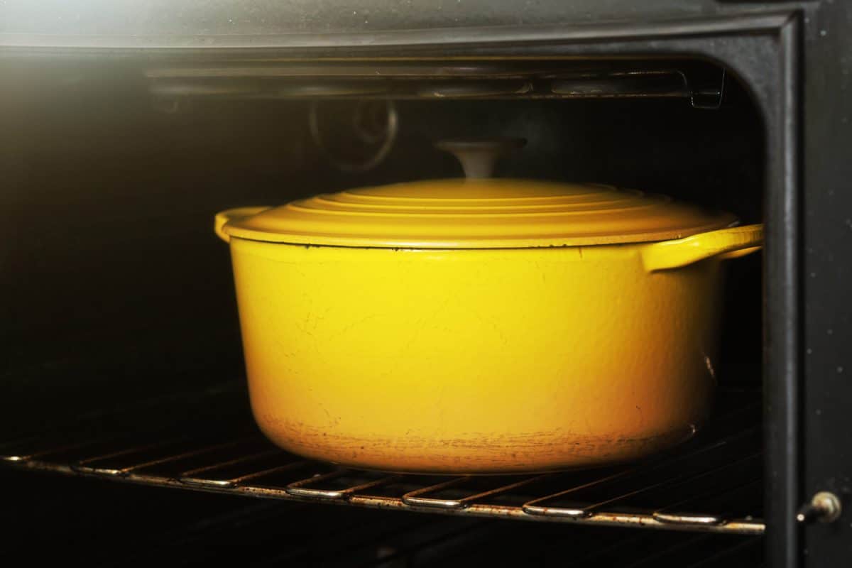 明亮的黄色搪瓷焙盘盘坐在烤箱的架子上。