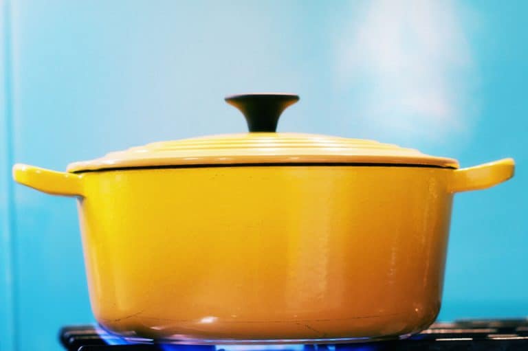 一个黄色的搪瓷砂锅，盖上盖子，放在点燃的煤气炉上，加热时产生蒸汽。搪瓷锅烤箱安全吗?