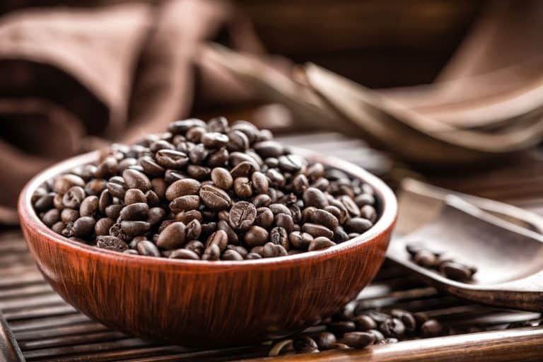 一杯黑咖啡豆放在一个木碗里，你可以用整个咖啡豆在过滤器里吗?
