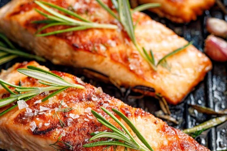 鲑鱼片撒上新鲜香草和柠檬汁烤板,你应该炸或烤鲑鱼吗?