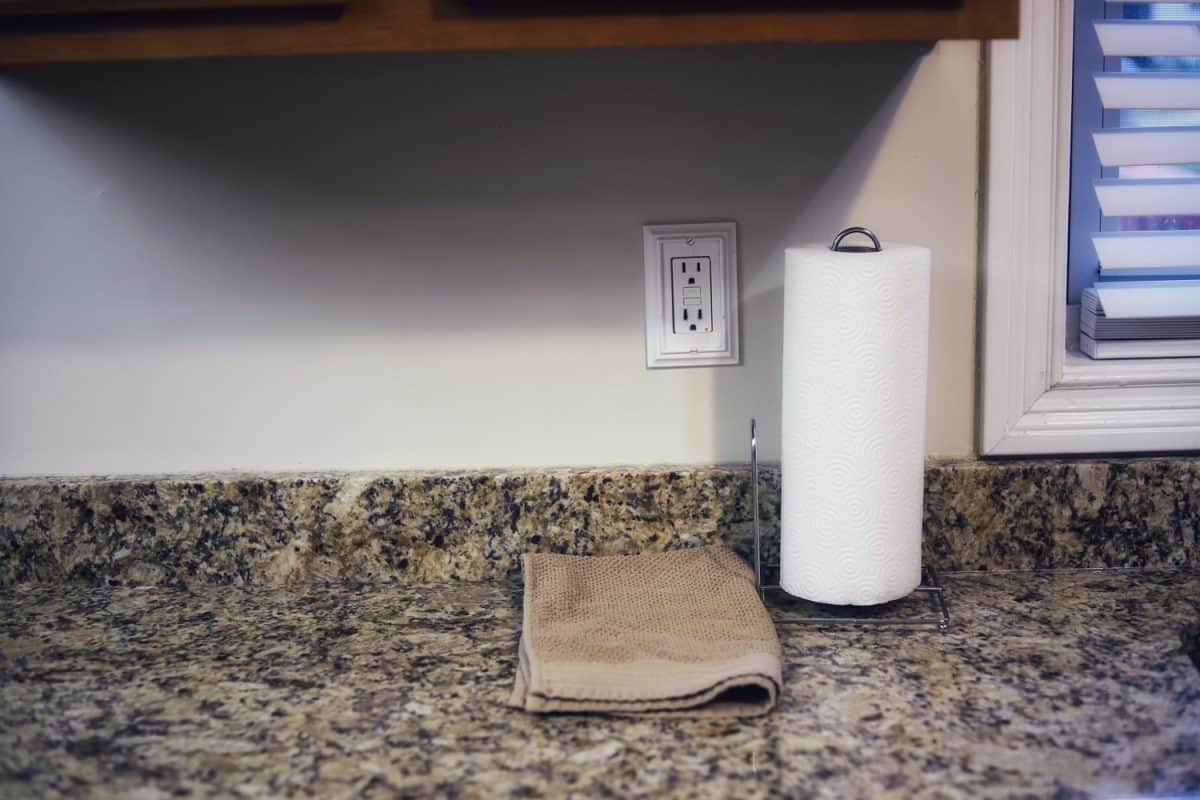 一卷毛巾纸和一块抹布放在花岗岩厨房柜台上bd手机下载