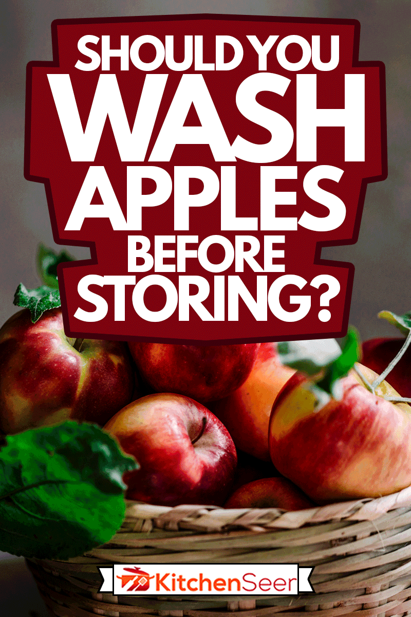 从苹果树上摘下来的新鲜红苹果放在柳条筐里，苹果储存前应该洗吗?＂width=