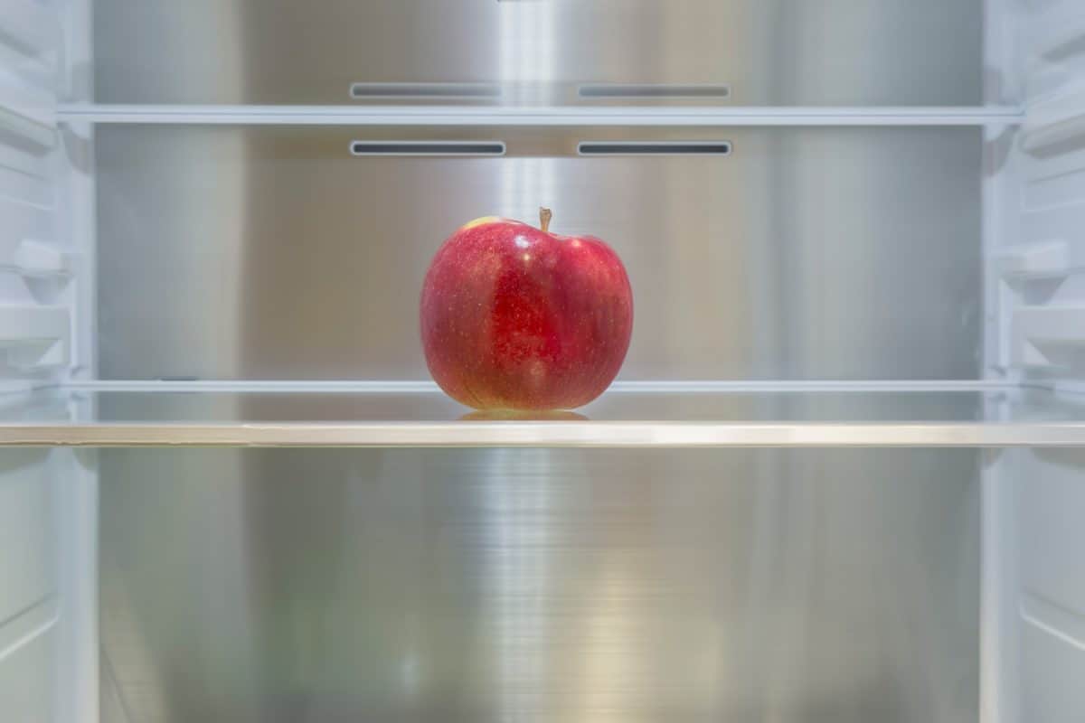 空冰箱里有一个苹果。焦点的概念。协助交付产品。＂width=