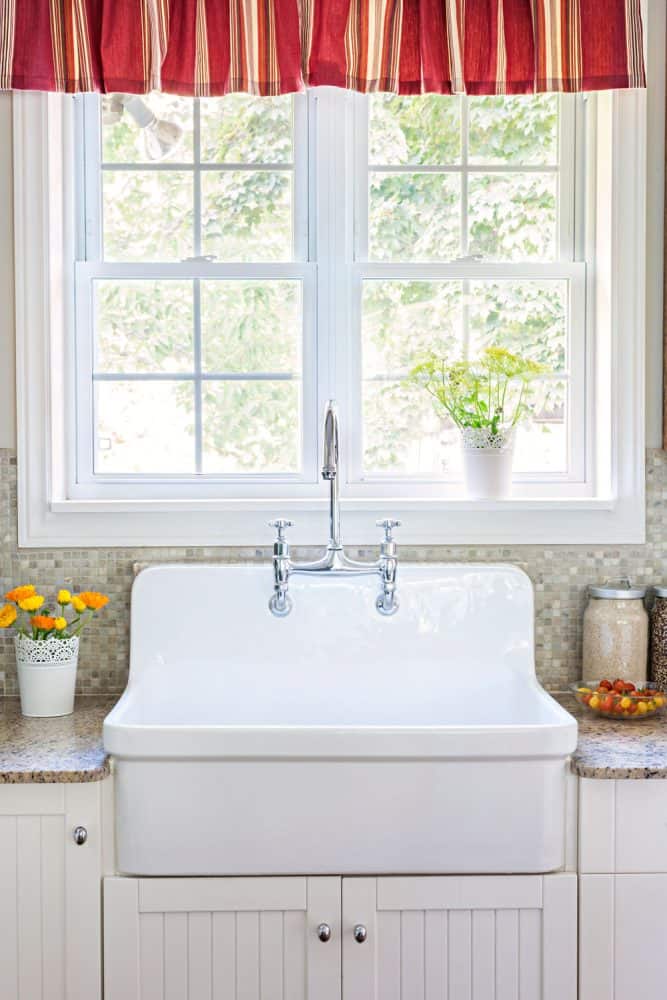 白色的经典设计的厨房水槽有些微框架窗口和一个小的红bd手机下载色的窗帘