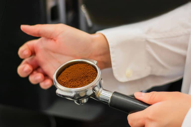 大师制作咖啡的咖啡师在食堂精细研磨混合芳香咖啡,咖啡豆在研磨机的进一步准备咖啡,咖啡可以太细的咖啡机?