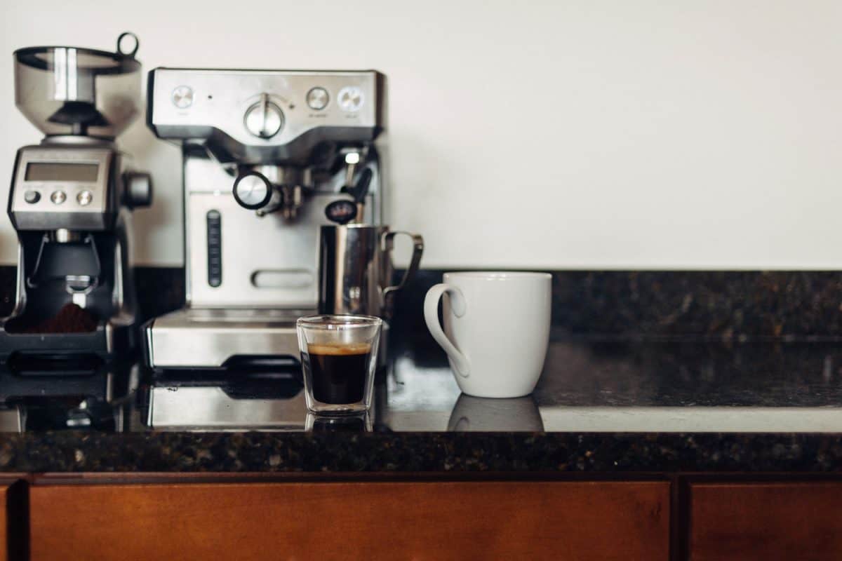 一杯浓缩咖啡和一台布雷维尔浓缩咖啡机放在工作台上
