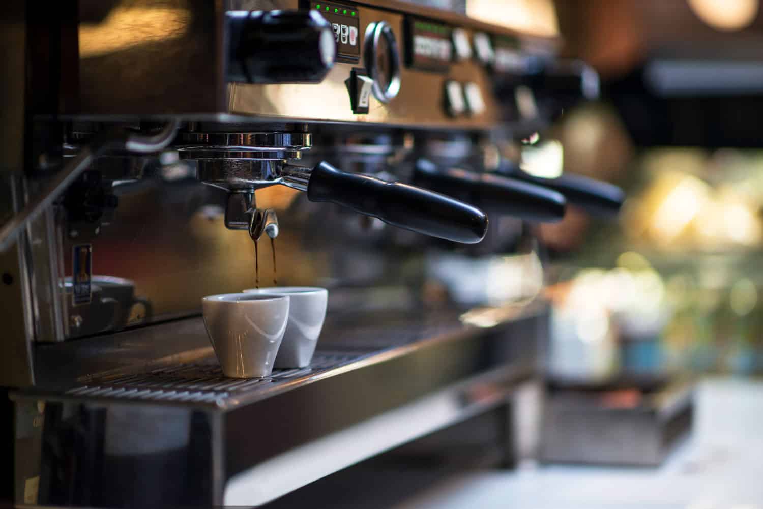 咖啡涌入两杯的咖啡机做一些咖啡拿铁咖啡。