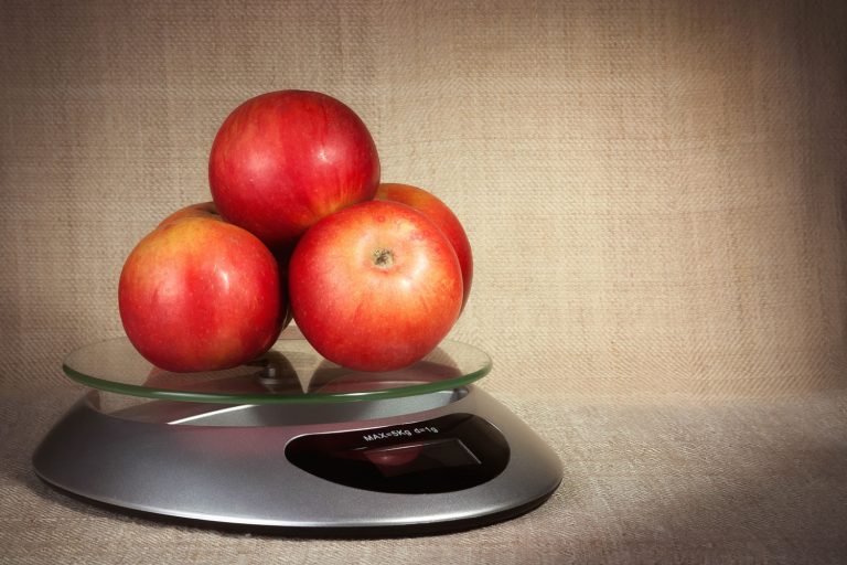 红苹果在厨房秤上一个棕色的背景,在一bd手机下载磅多少苹果?