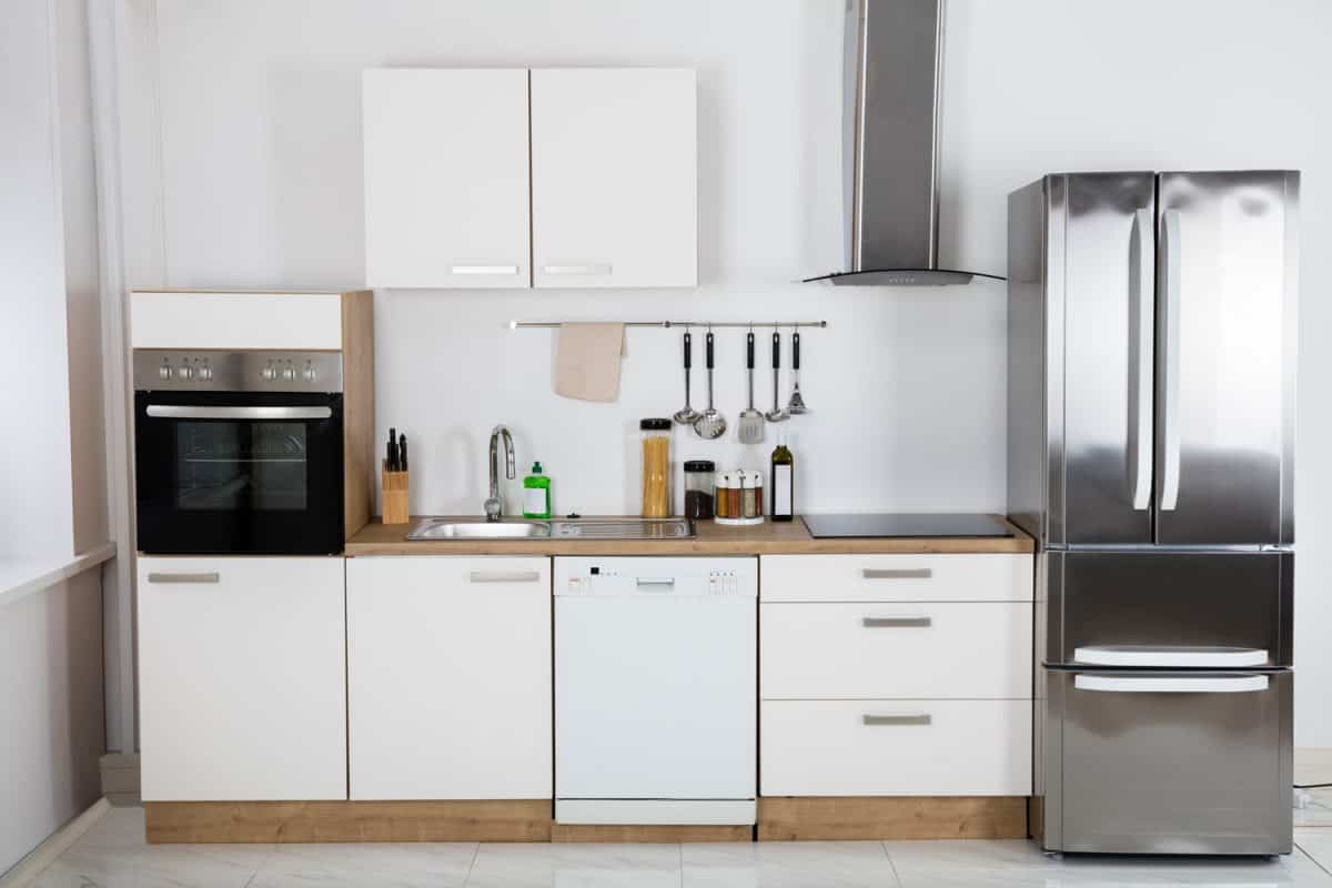小而波西米亚主题的厨房，白色的橱柜和一边的冰箱bd手机下载