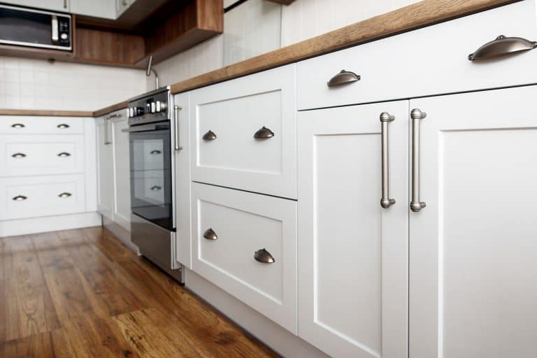 白色的橱柜,不锈钢处理酒吧在一个乡村主题厨房,绘画厨柜,下面是如何得到光洁度bd手机下载