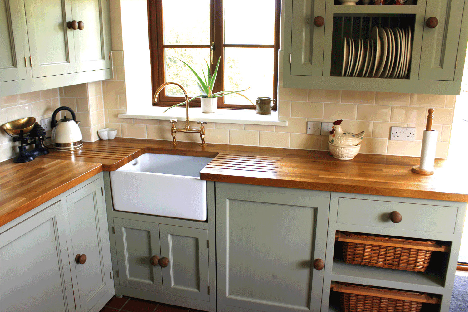 传统的乡村厨房，有一个带煤气灶的大炉灶，bd手机下载鸭蛋绿色的橱柜和壁柜，一个白色的陶瓷水槽