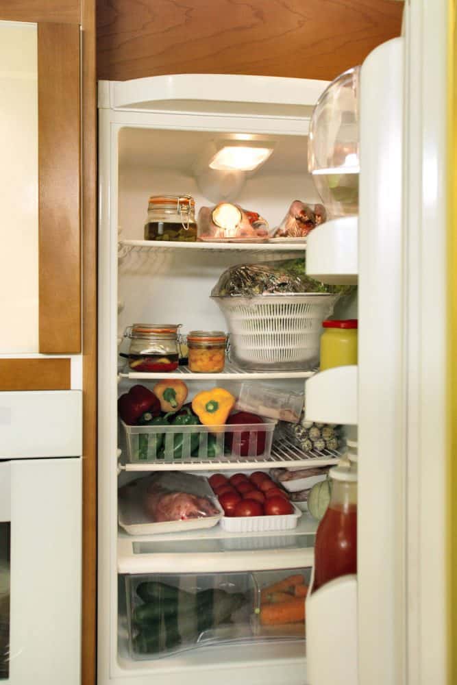 一个打开的冰箱里有很多蔬菜和水果