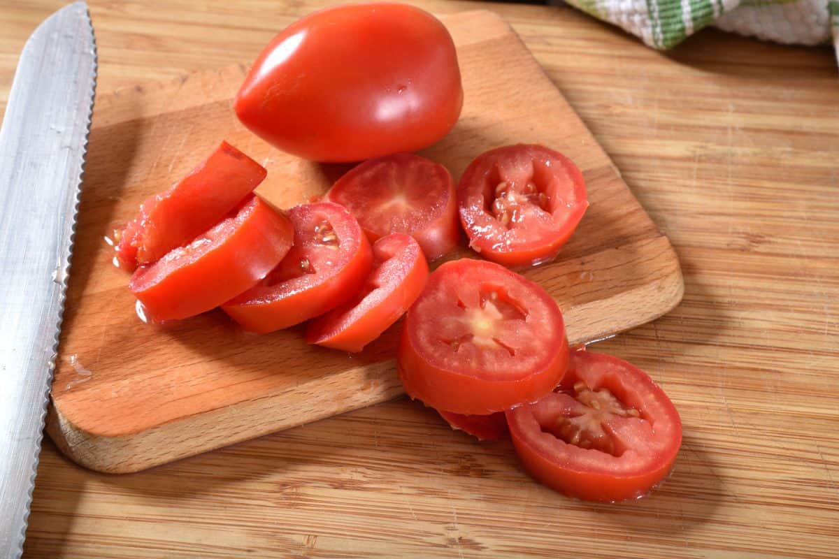 砧板上的新鲜番茄片＂width=