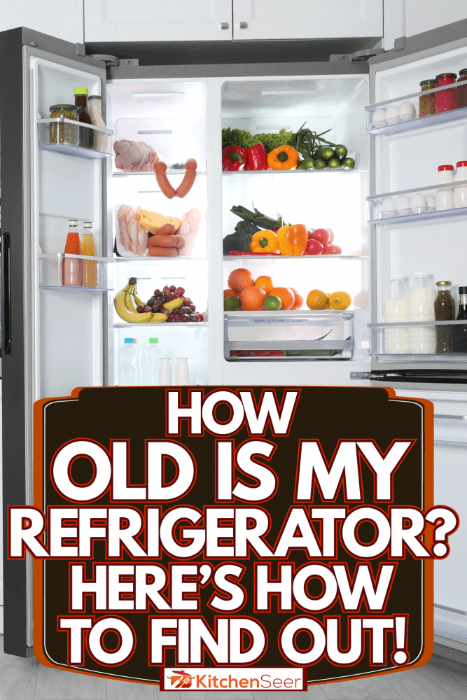 一个打开的双门冰箱，里面有很多生活必需品，我的冰箱有多老?以下是如何找到答案!