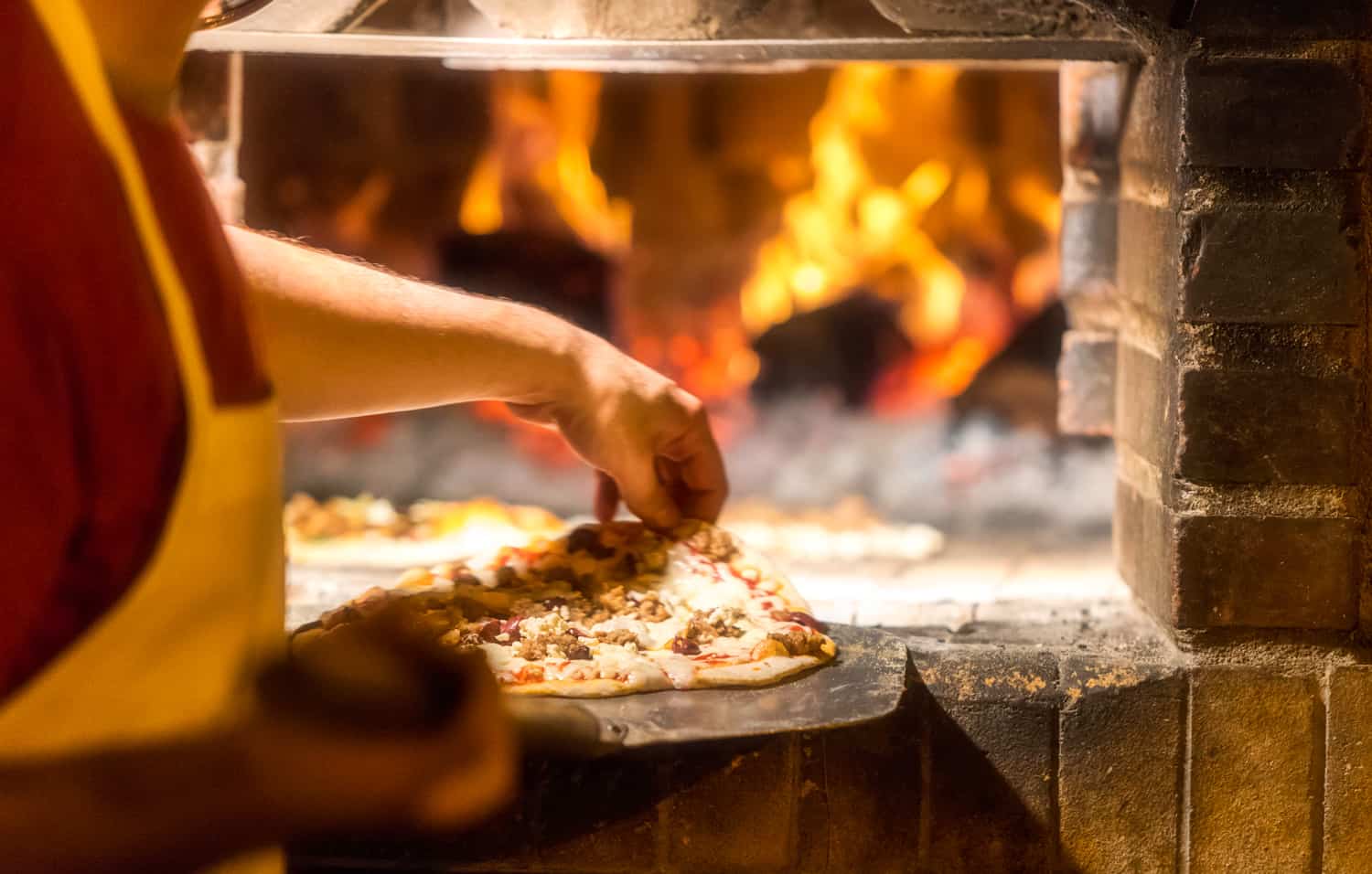 在披萨店的柴火砖烤炉中烹饪披萨
