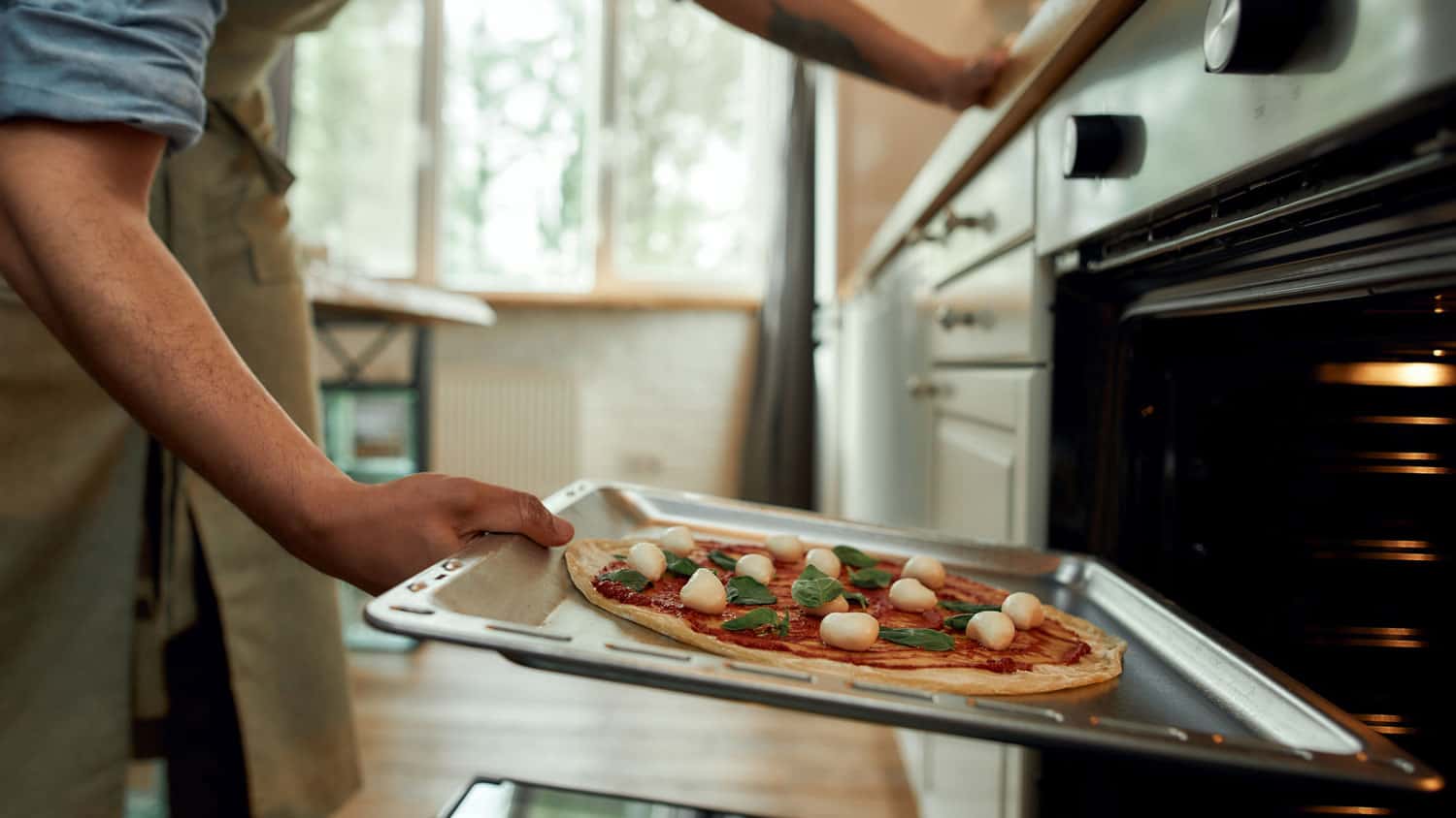 一个男人的短镜头，专业厨师在家里做披萨。