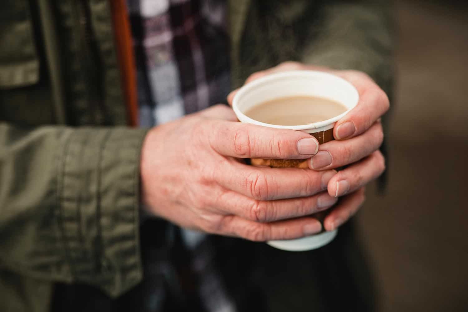 高级的人拿着一杯茶保持双手温暖的冬天