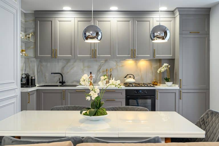 灰色和白色的当代经典厨房与餐桌设计在现代室内风格,前视图,什么颜色的灰色bd手机下载厨柜的铰链和旋钮半岛电竞体育平台app