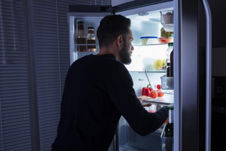 一个人寻找食物在冰箱,冰箱可以保存在寒冷的温度吗?