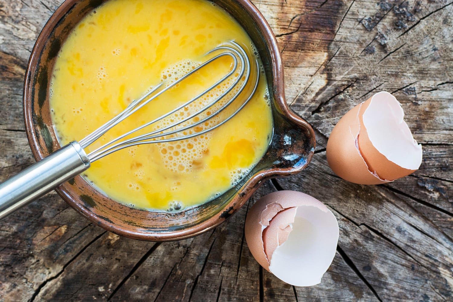打好的鸡蛋在陶瓷碗里搅拌