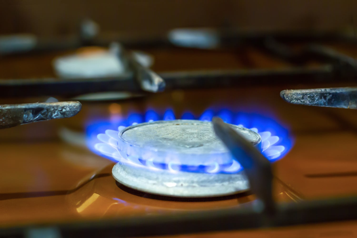 旧煤气炉燃烧器在家庭厨房特写。bd手机下载在公寓里做饭用的低蓝色火焰。烤箱火的细节在柜台上，柔和的焦点