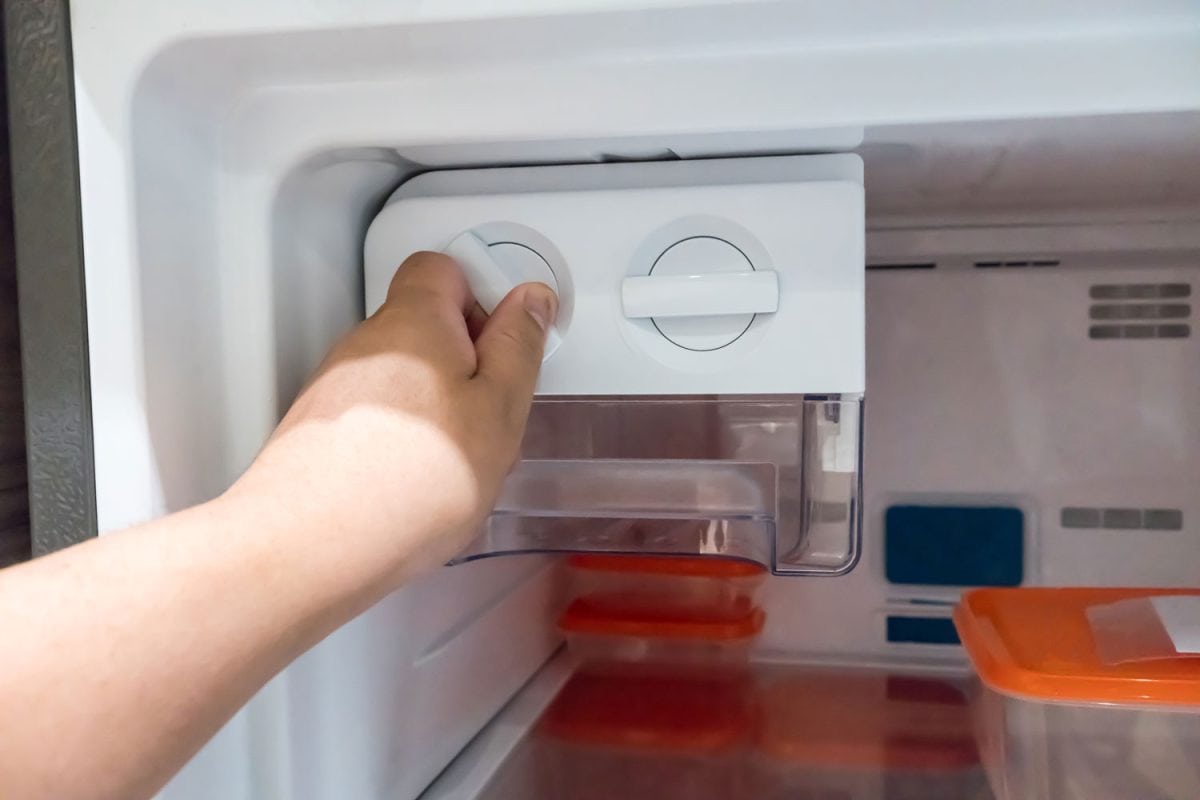 女人在改变冰箱的温度