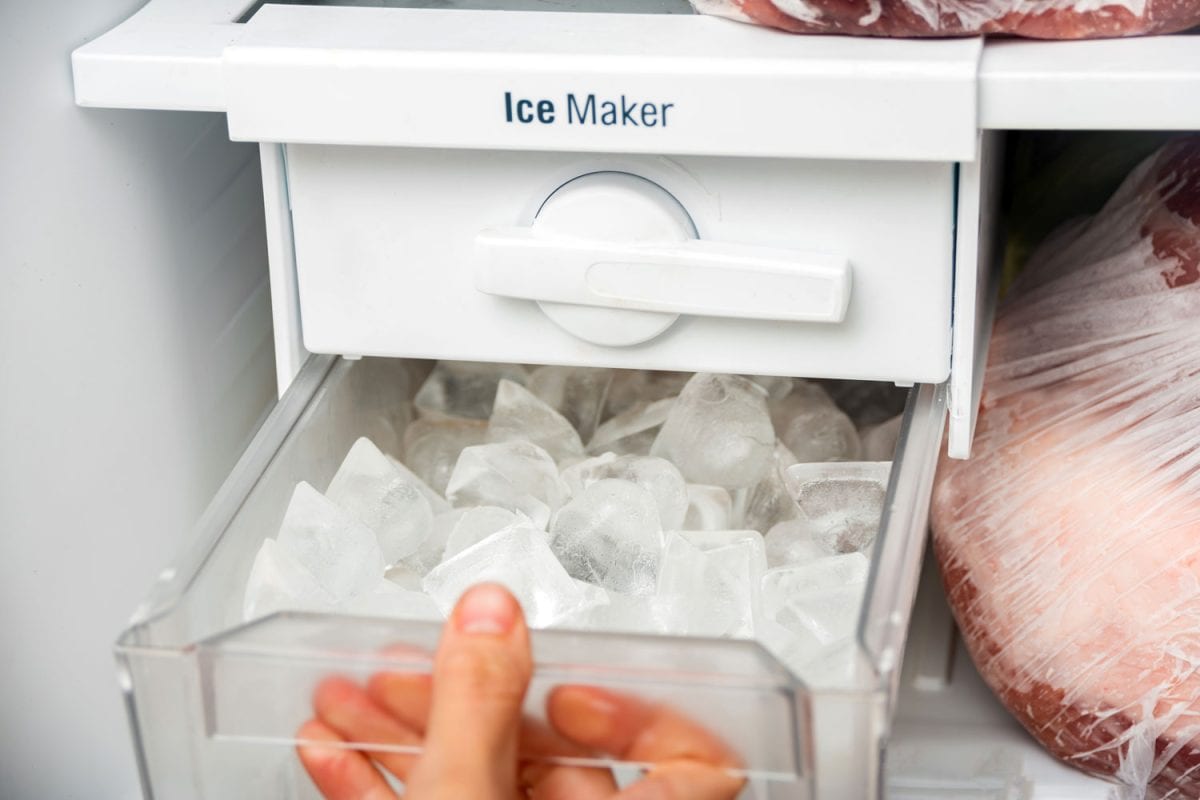 女人从制冰机里取冰