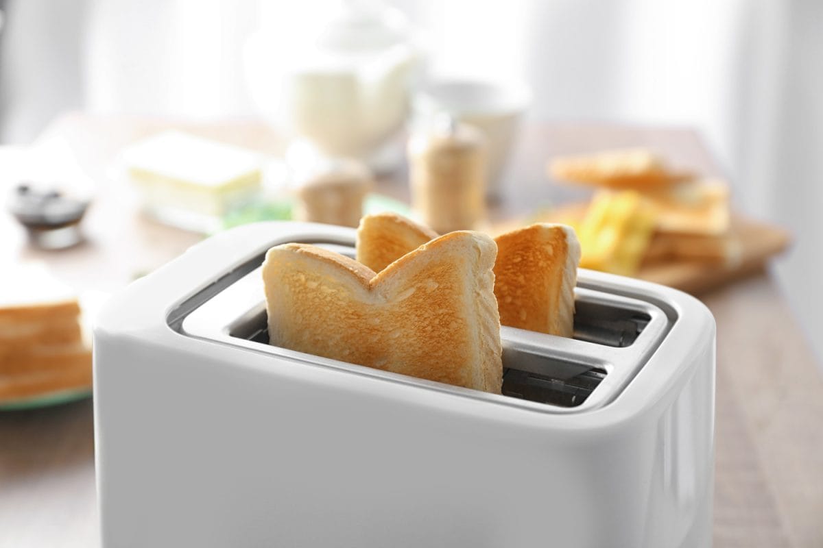 烤面包机与美味的早餐吐司放在桌子上