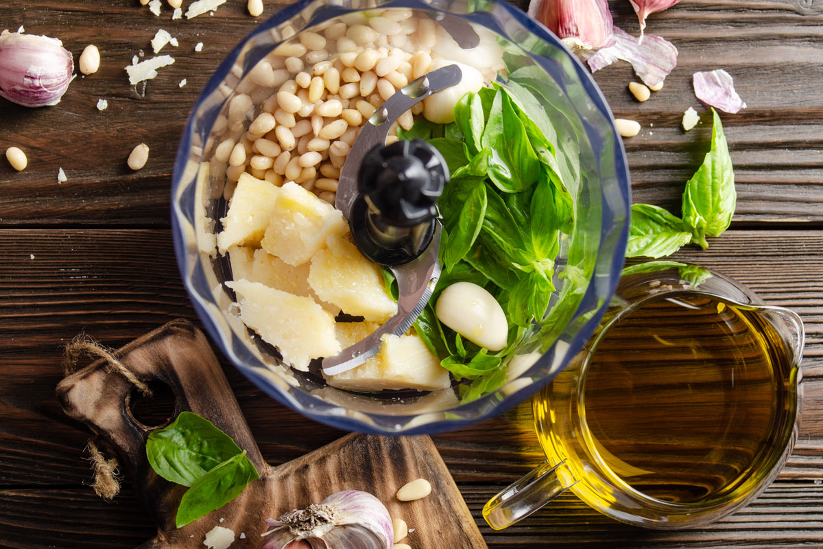 Ingredients for italian national traditional genovese pesto sauce in food processor bowl